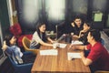 Younger asian freelance team relaxing on working table in office Royalty Free Stock Photo