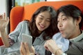 Younger asian man and woman happiness emotion when looking on sm Royalty Free Stock Photo