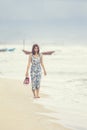 Younger asian woman walking on sea beach