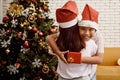 Younger brother hugging sister while holding gift box behind