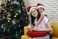 Younger brother hugging sister while sitting on sofa in living room