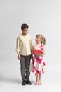 The younger girl gives a gift to the older boy - brother or friend Royalty Free Stock Photo