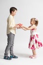 The younger girl gives a gift to the older boy - brother or friend Royalty Free Stock Photo