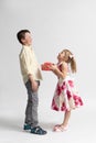 The younger girl gives a gift to the older boy - brother or friend