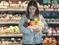 Girl holding fruits and vegetables in an eco bag on the background of the store Royalty Free Stock Photo