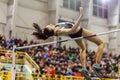 Young girl jumping over bar in high jump contest. Royalty Free Stock Photo
