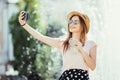 Youngpretty girl take selfie from hands with phone on summer city street. Urban life concept. Royalty Free Stock Photo