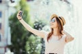 Youngpretty girl take selfie from hands with phone on summer city street. Urban life concept. Royalty Free Stock Photo