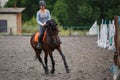 Young girl riding bay horse on equestrian sport training Royalty Free Stock Photo