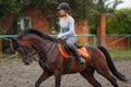 Young girl riding bay horse on equestrian sport training Royalty Free Stock Photo