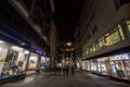 Youngsters, czech teenagers, walking in a deserted pedestrian street of Brno, Ceska Ulice, at night, surrounded by closed shops