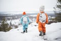 youngsters dressed in snowsuits hiking