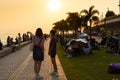 Youngsters students boy and girl chat and walk during sunset in West Kowloon Waterfront Promenade, Hong Kong in evening. back