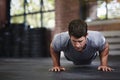 Your body achieves what you believe. a young man doing pushups in a gym. Royalty Free Stock Photo