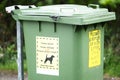 Your dog mess fine notice and please dispose of litter and waste sign on green wheelie bin Royalty Free Stock Photo