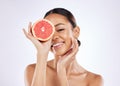 Your dream skin is one step away. a beautiful young woman covering her eye with a grapefruit against a studio background Royalty Free Stock Photo