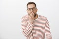 Your face make me puke. Portrait of disgusted european guy feeling unwell, covering mouth with palm and feeling dizzy Royalty Free Stock Photo