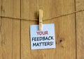 Your feedback matters symbol. White paper with text `your feedback matters`, clip on wood clothespin. Beautiful wooden backgroun Royalty Free Stock Photo