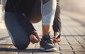 Your fitness starts now. a fit young woman tying her shoelaces before going for a run on the promenade.