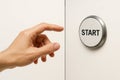 Your hand reaches for the START button on the wall. Space for text. Royalty Free Stock Photo