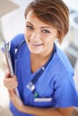 Your health is in good hands. Portrait of an attractive young doctor in scrubs holding a clipboard. Royalty Free Stock Photo