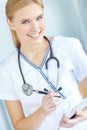 Your health is in good hands. Portrait of a smiling nurse writing notes in her notepad. Royalty Free Stock Photo