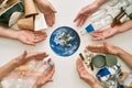 Your life, your world, our future. Conceptual flatlay with many hands and different waste, garbage types reaching planet Royalty Free Stock Photo