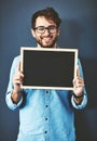 Your message would read loud and clear over here. Studio portrait of a young man holding a blackboard against a grey