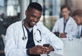 Your messages always make me smile. a young male doctor using his smartphone while taking a break. Royalty Free Stock Photo