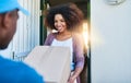 Your package, maam. a postal worker delivering a package to a young female customer. Royalty Free Stock Photo