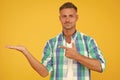 Your promotion here. smiling guy pointing finger, copy space. male fashion model shirt. presenting product. goods for Royalty Free Stock Photo