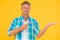 Your promotion here. smiling guy pointing finger, copy space. male fashion model shirt. presenting product. goods for Royalty Free Stock Photo