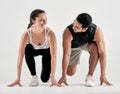 Your race, your pace. Studio shot of a sporty young man and woman in starting position against a white background. Royalty Free Stock Photo