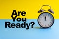 ARE YOUR READY inscription written and Alarm Clock on blue yellow background Royalty Free Stock Photo
