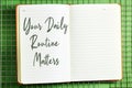 Your Daily Routine Matters concept for practice of regularly notebook above fence background