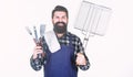 Your satisfaction guaranteed with cooking tool set. Happy hipster holding stainless steel tools. Bearded man with Royalty Free Stock Photo