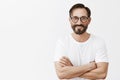 At your service. Charming carefree and confident european man with beard and dark hair in glasses and white t-shirt