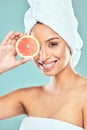 Your skin will thank you. a young woman covering her eye with a slice of grapefruit against a studio background. Royalty Free Stock Photo