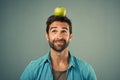 Your target should be a healthier lifestyle. Studio shot of a handsome young man posing with an apple on his head Royalty Free Stock Photo