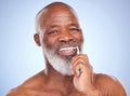Your teeth does more than chew, take care of them. Studio portrait of a mature man brushing his teeth against a blue Royalty Free Stock Photo