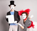 Your text here. Actors mimes holding empty blank board. Colorful studio portrait with gray background. April fools day Royalty Free Stock Photo