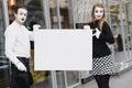 Your text here. Actors mimes holding empty white letter. Colorful portrait with gray background. April fools day Royalty Free Stock Photo