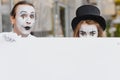 Your text here. Actors mimes holding empty white letter. Colorful portrait with gray background. April fools day Royalty Free Stock Photo