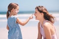 Your turn now mommy. a little girl applying suntan lotion to her mothers face at the beach. Royalty Free Stock Photo