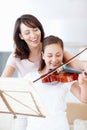 Youre amazing, my girl. A laughing mother helping her smiling daughter practice the violin.