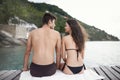 Youre so beautiful to me. Rear view shot of an affectionate young couple sitting together on a jetty. Royalty Free Stock Photo