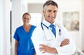 Youre in capable hands. Portrait of a male doctor standing with his arms crossed in the hospital with a female colleague Royalty Free Stock Photo