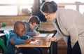 Youre doing a great job, keep it up. an elementary school teacher helping her students in the classroom.