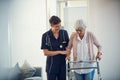 Youre doing so great. a young nurse assisting a senior woman walk using a walker in a nursing home.