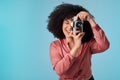 Youre giving me some awesome memories for my collection. Studio shot of a young woman using a camera against a blue